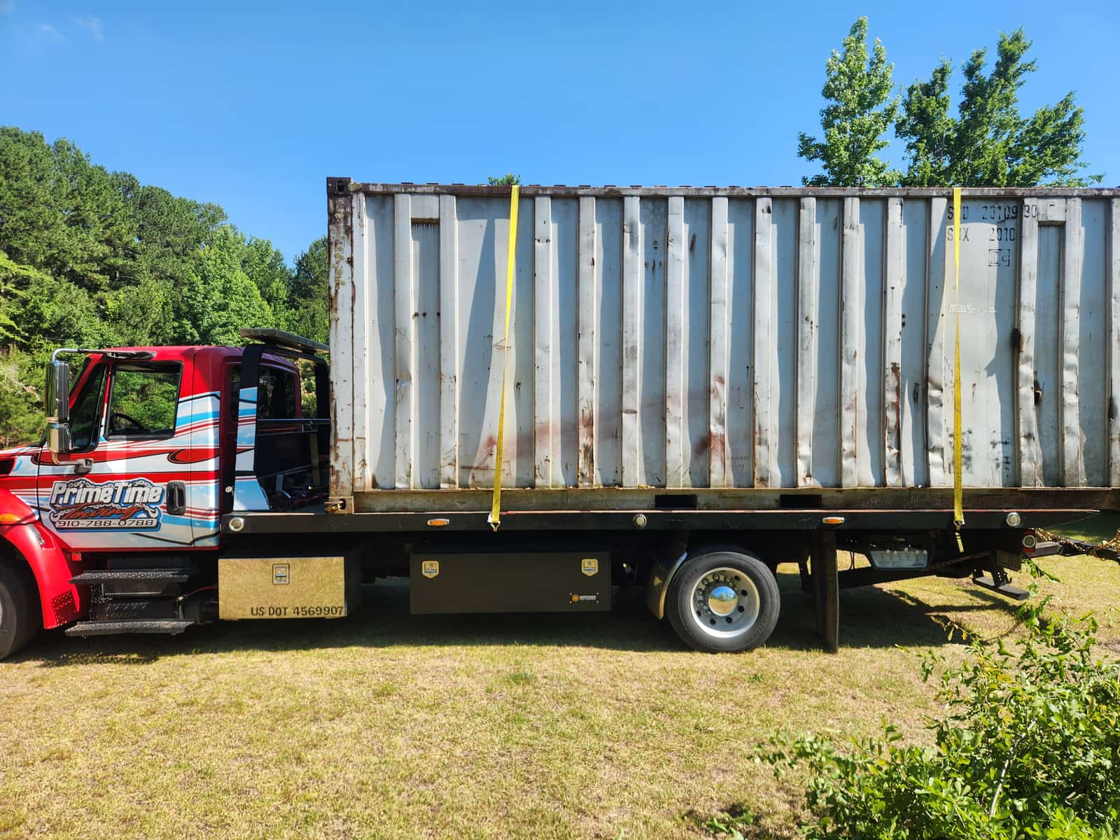 20-foot storage container strapped down and transported on the Prime Time Towing flatbed